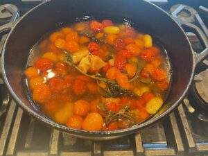 After cooking, the cherry tomatoes are still whole. the sauce is a combination of juice and olive oil.