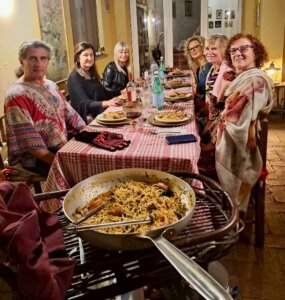 A dinner party with friends in Calabria featuring spaghetti with gamberi (shrimp), arugula, orange, and cream.