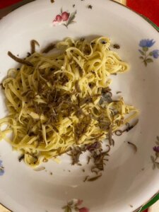 A plate with grated truffle over pasta.